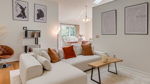 A modern living room with a sectional sofa, a wooden coffee table, and artwork on the walls.