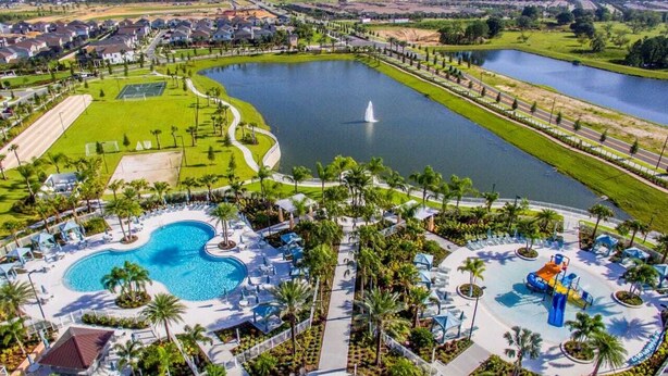 A resort with a large swimming pool, a water park, and a tennis court.