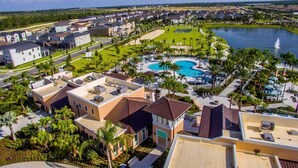 A residential area with a large swimming pool, multiple buildings, and a lake.