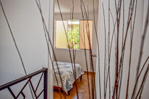 Enter a serene bedroom with a bed and garden view.