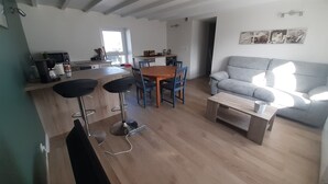 Ett modernt kök med en matplats, en grå soffa och en kaffemaskin.