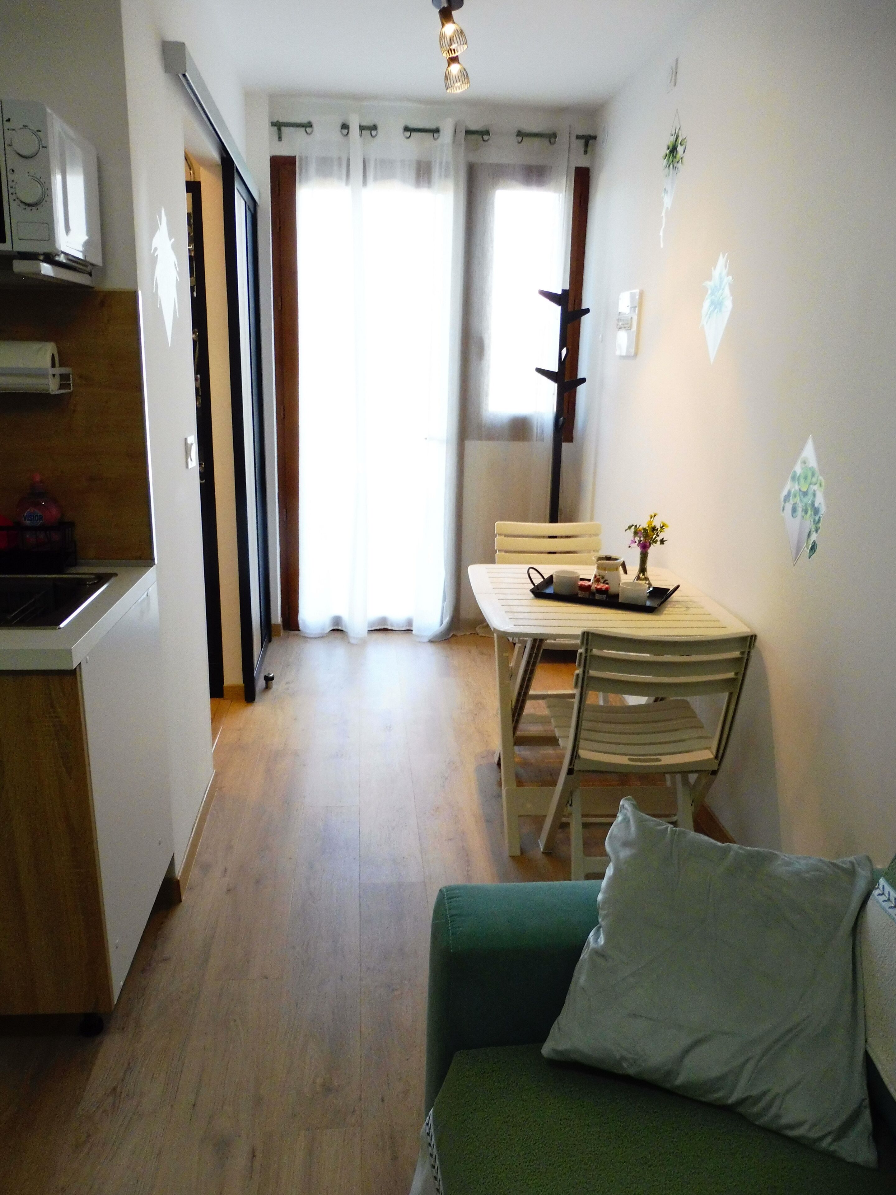 A compact living space with a kitchenette, a dining area, and a sofa.
