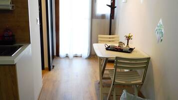 A compact living space with a kitchenette, a dining area, and a sofa.