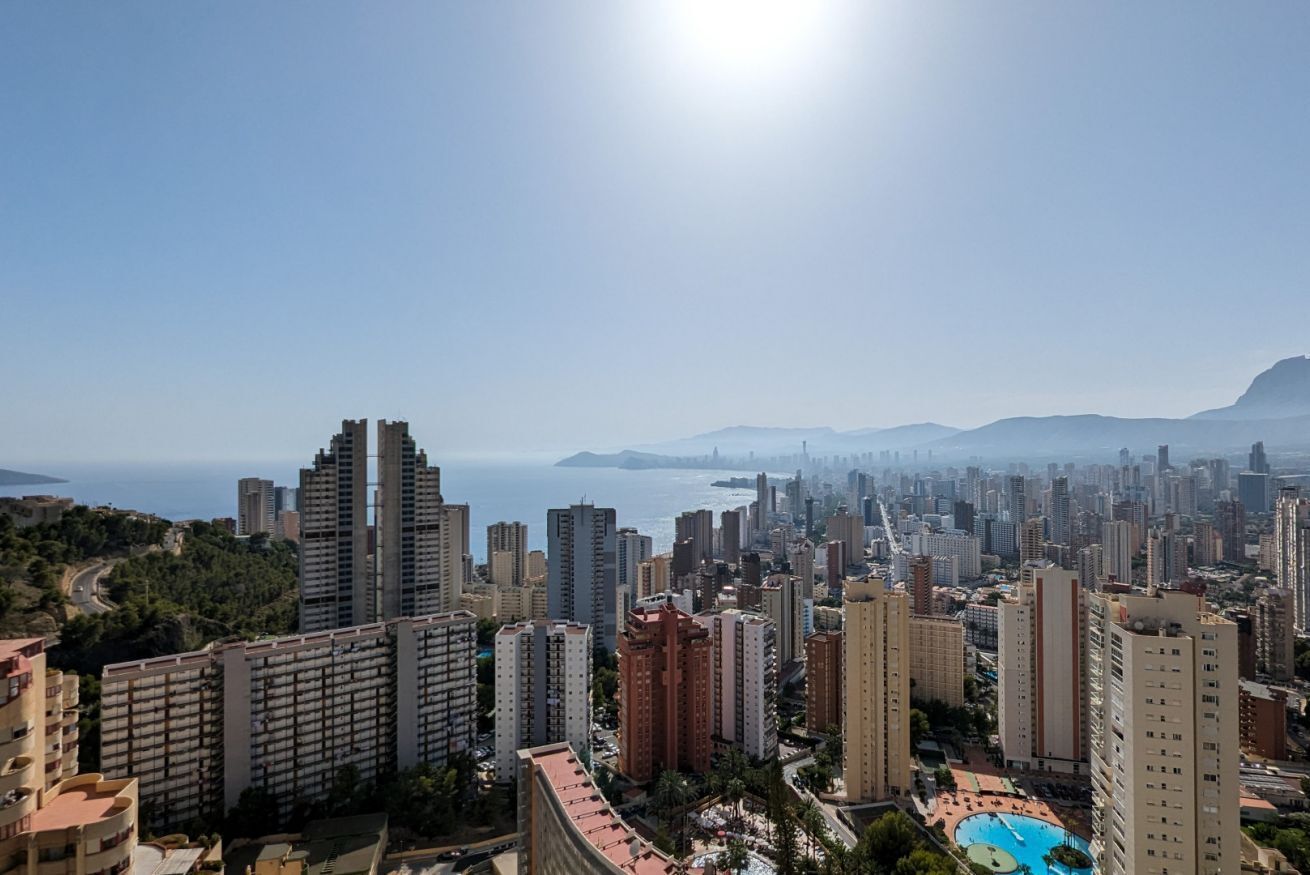 A high-rise urban area with a view of the sea and mountains.