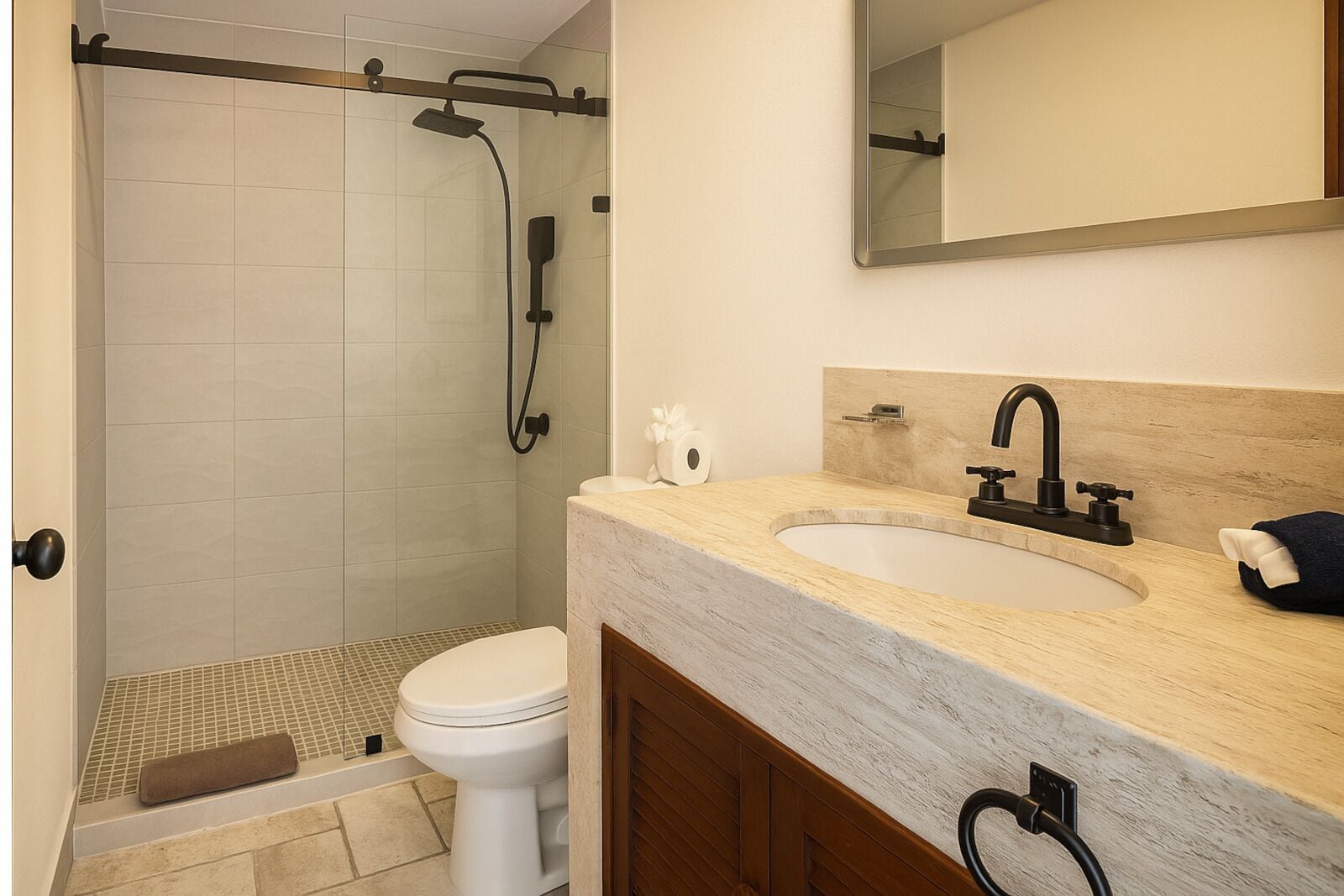 Een badkamer met douche, toilet, wastafel en spiegel.