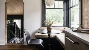 A modern kitchen with a built-in island, a pendant light, and a view of the outdoors. - Hood Canal Beach Retreat (Belfair)