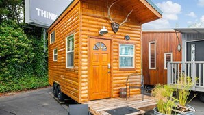 A small log cabin with a wooden door, windows, and a porch.