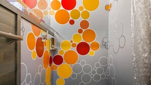 A bathroom with a colorful wall design featuring large circles in various colors. - The Modern - Custom Tiny Home w/ Modern Vibe (Portland)