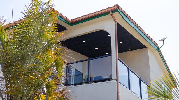 Un edificio de dos pisos con un balcón y una antena parabólica.