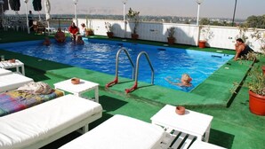 A rooftop pool with lounge chairs, a diving board, and potted plants. - St.Joseph Hotel (Luxor)
