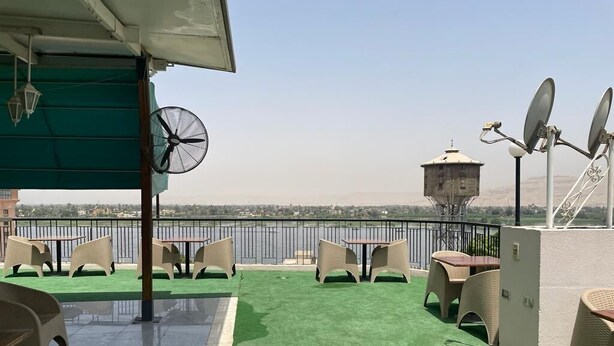 A rooftop terrace with green artificial turf, outdoor furniture, and satellite dishes. - St.Joseph Hotel (Luxor)