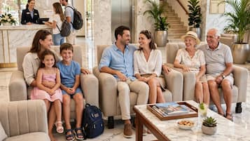 A hotel lobby with a marble floor, seating area, reception desk, and a sign for the 'Atlantis House' on the wall.