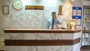 A reception desk with a marble top and a clock on the wall. - St.Joseph Hotel (Luxor)