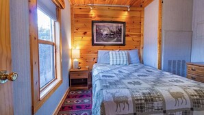 A wooden-paneled bedroom with a bed, a nightstand, a framed picture, and a window. -  Quiet hideout w/ Hot Tub & fire pit! BrysonCity! Pet Friendly! GSMR NOC  (Bryson City)