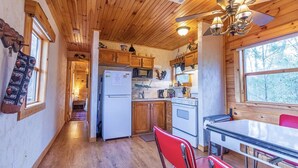A wooden cabin interior with a kitchen, dining area, and a hallway leading to a bedroom. -  Quiet hideout w/ Hot Tub & fire pit! BrysonCity! Pet Friendly! GSMR NOC  (Bryson City)