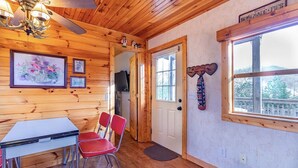 A wooden interior with a dining table, red chairs, a ceiling fan, framed artwork, and a window with a view. -  Quiet hideout w/ Hot Tub & fire pit! BrysonCity! Pet Friendly! GSMR NOC  (Bryson City)