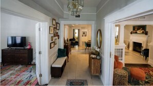 Un salón amplio con televisor, chimenea y un pasillo que conduce a un comedor.