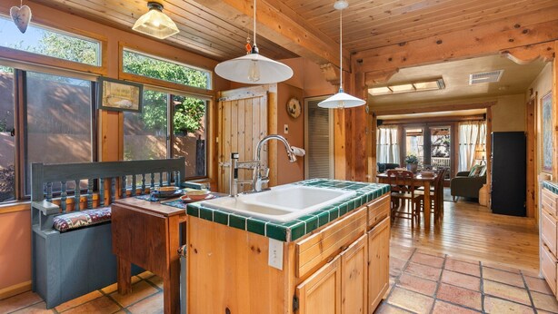 A wooden interior with a kitchen island, wooden bench, and dining area. - Adorable Santa Fe 3 Bedroom Home! (Santa Fe)