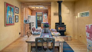 A wooden dining table with chairs, a central vase, and a fireplace. - Adorable Santa Fe 3 Bedroom Home! (Santa Fe)