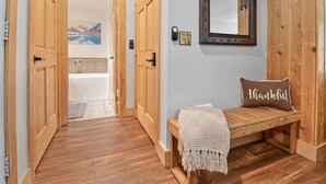 A wooden bench with a 'thankful' pillow, a mirror, and a door leading to a bathroom with a mountain view. - TRUE SKI IN / SKI OUT, POOL, HOT TUB, GYM, TENNIS COURTS, CLOSE TO DOWNTOWN (Park City)