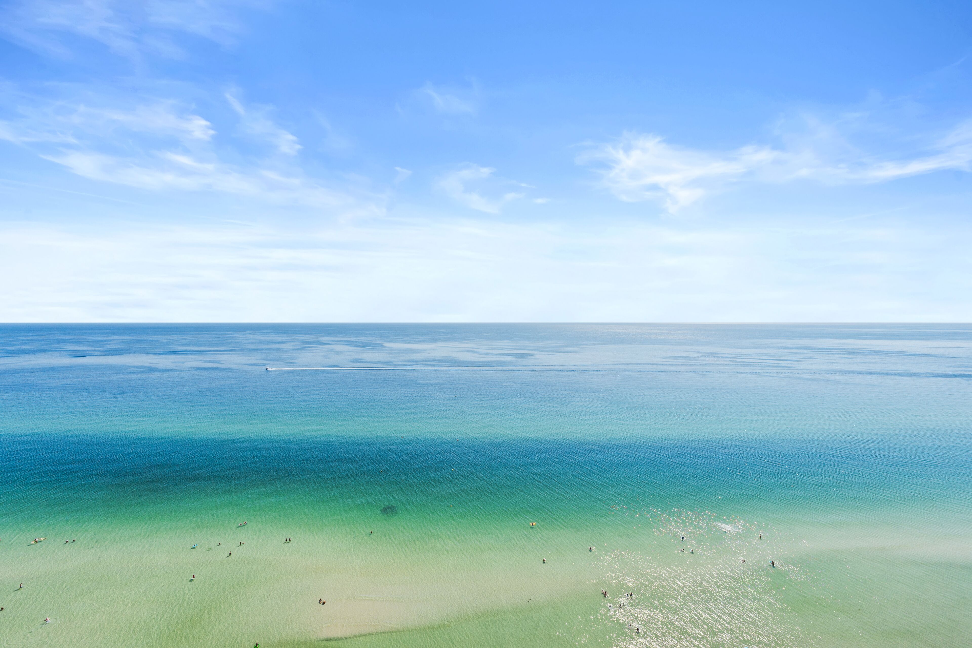 A beach with clear turquoise water and a sandy shore.