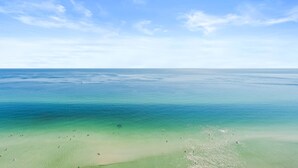 En strand med klart turkis vand og en sandet kyst.