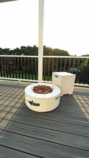 A deck with a circular planter and a rectangular planter, surrounded by a railing. - The Lily Pond House-Walk to Beach, SPA, Sleeps 6 (Gold Beach)