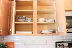 Une cuisine avec des meubles de rangement en bois, une cuisinière et un plan de travail.