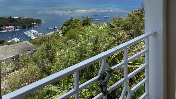Un balcon avec vue sur un port de plaisance et la mer.