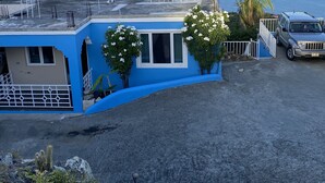 Un bâtiment bleu avec vue sur la mer et les montagnes.