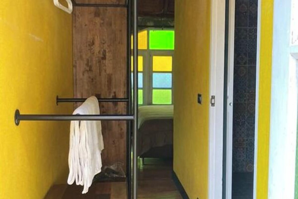 A narrow hallway with yellow walls and a wooden door frame.
