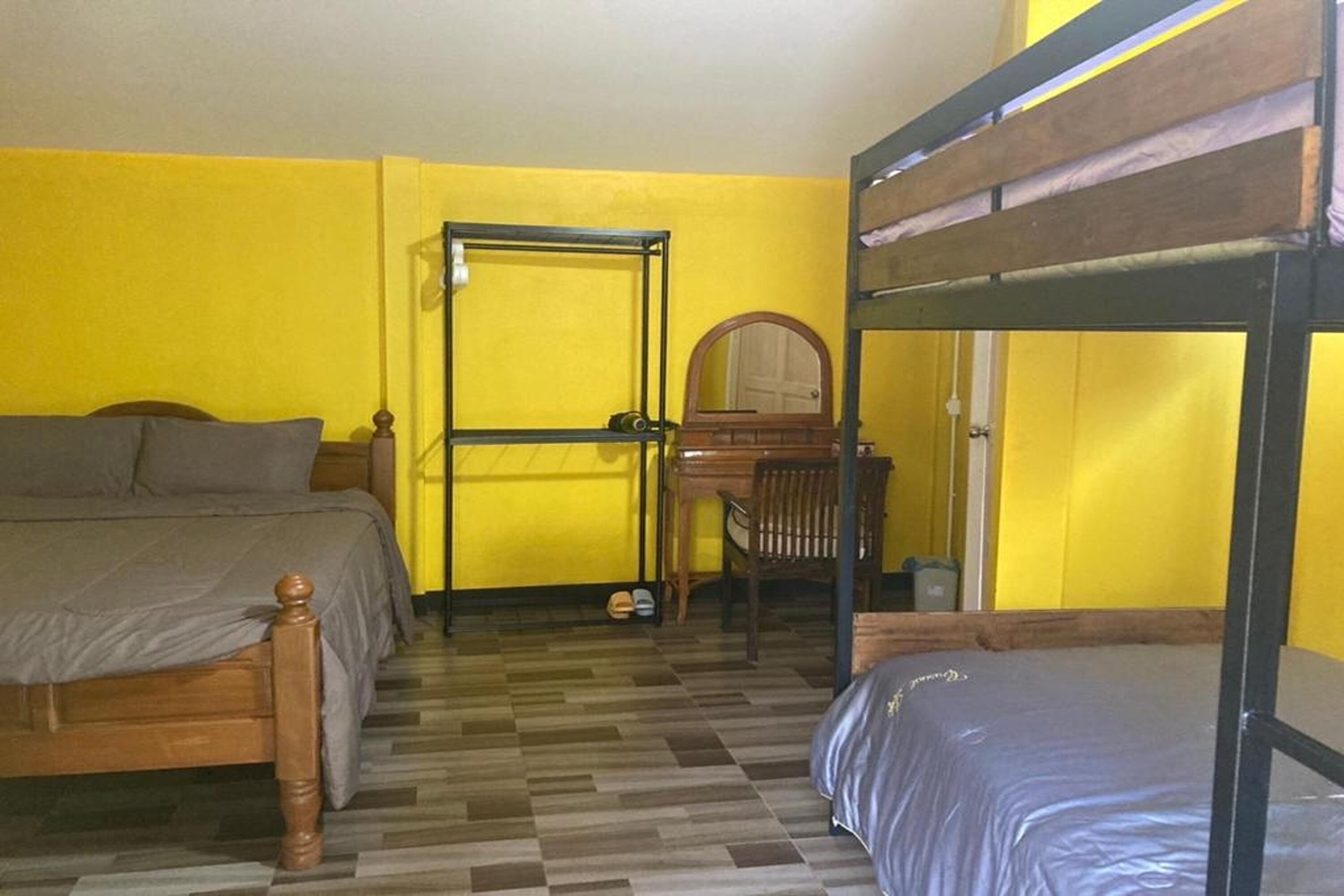 A room with a bed, a desk, and a bunk bed.