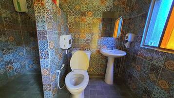 A bathroom with a toilet, sink, and patterned tiles.