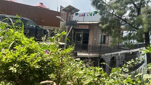 A building with a balcony and a sign that reads "NINE JUICE BAR". - N V Villa Homestay (Kasauli)