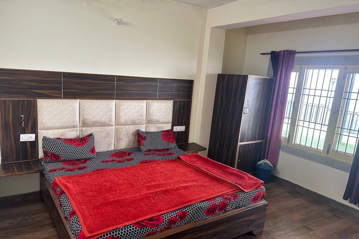 A bedroom with a bed, a wardrobe, and a window with curtains.
