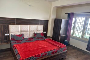 A bedroom with a bed, a wardrobe, and a window with curtains. - N V Villa Homestay (Kasauli)