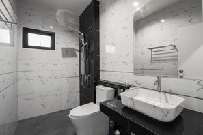 Une salle de bain moderne équipée de toilettes, d’une douche et d’un lavabo.