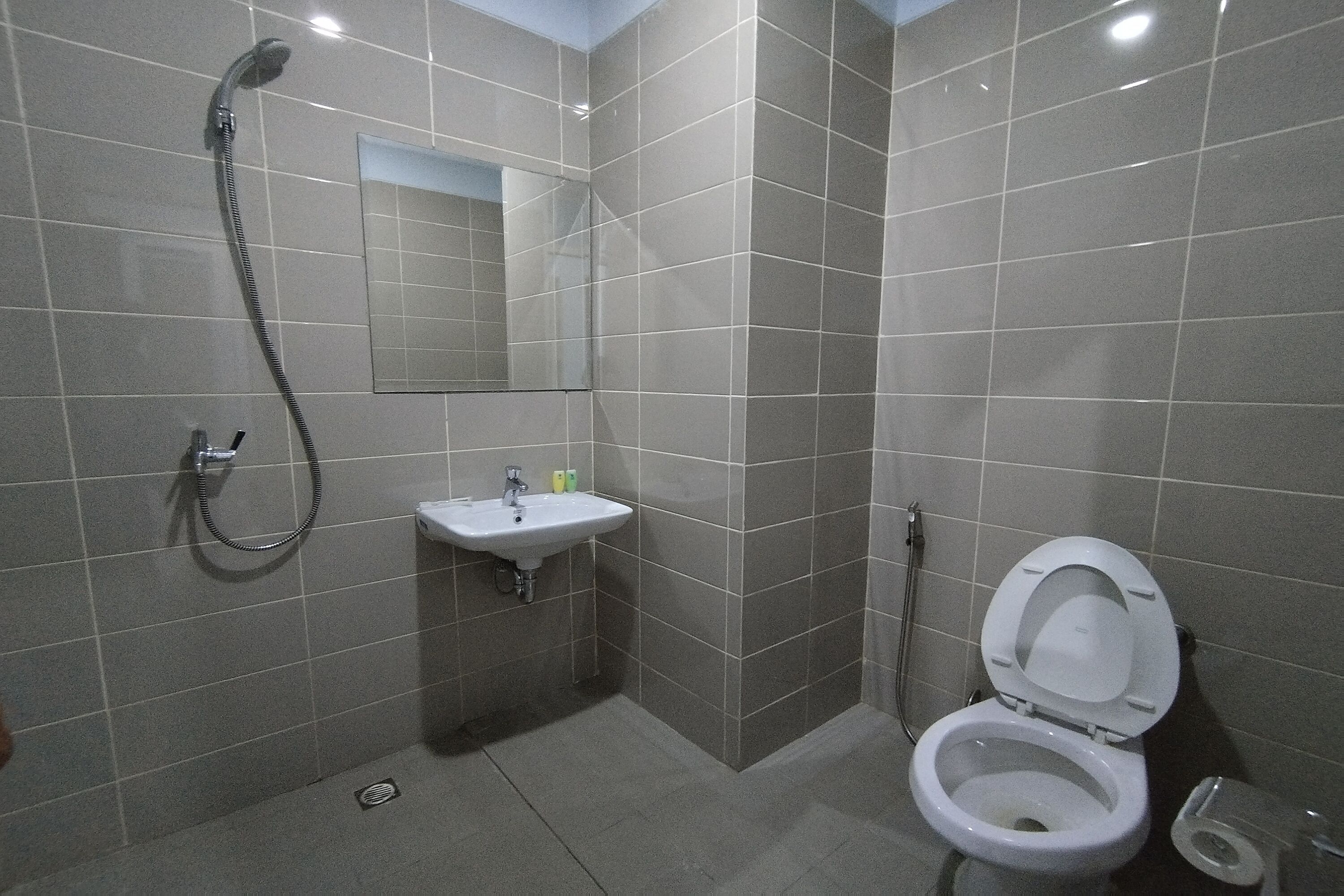 A bathroom with a shower, sink, and toilet.