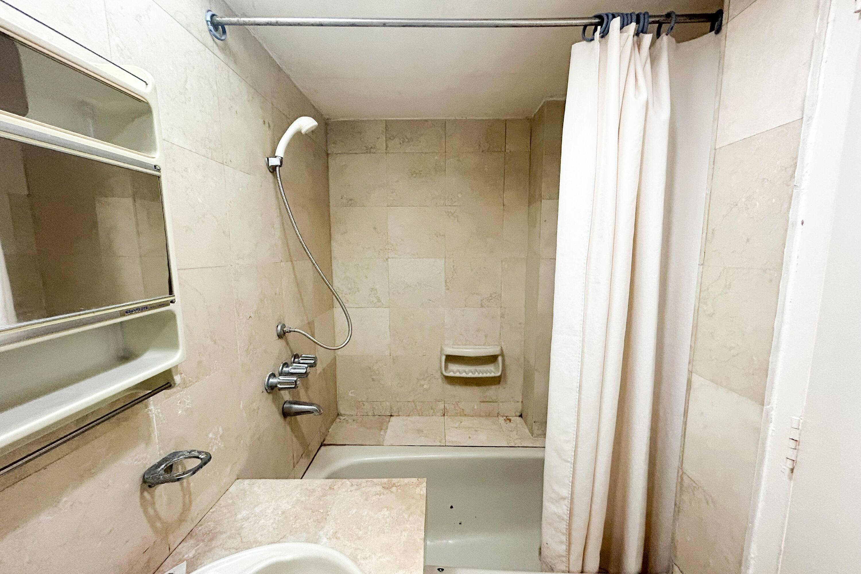 Une petite salle de bain avec une baignoire, une douche et des toilettes.