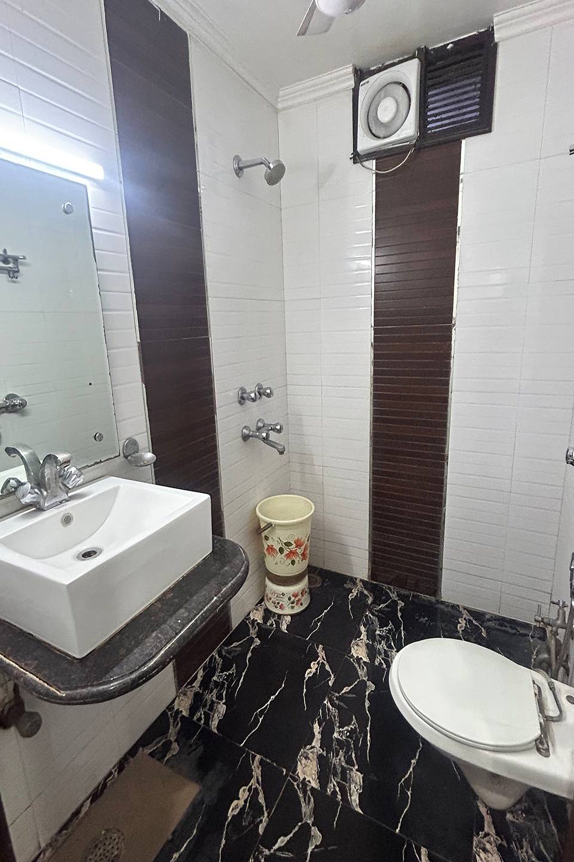 A bathroom with a white sink, a toilet, and a shower area.