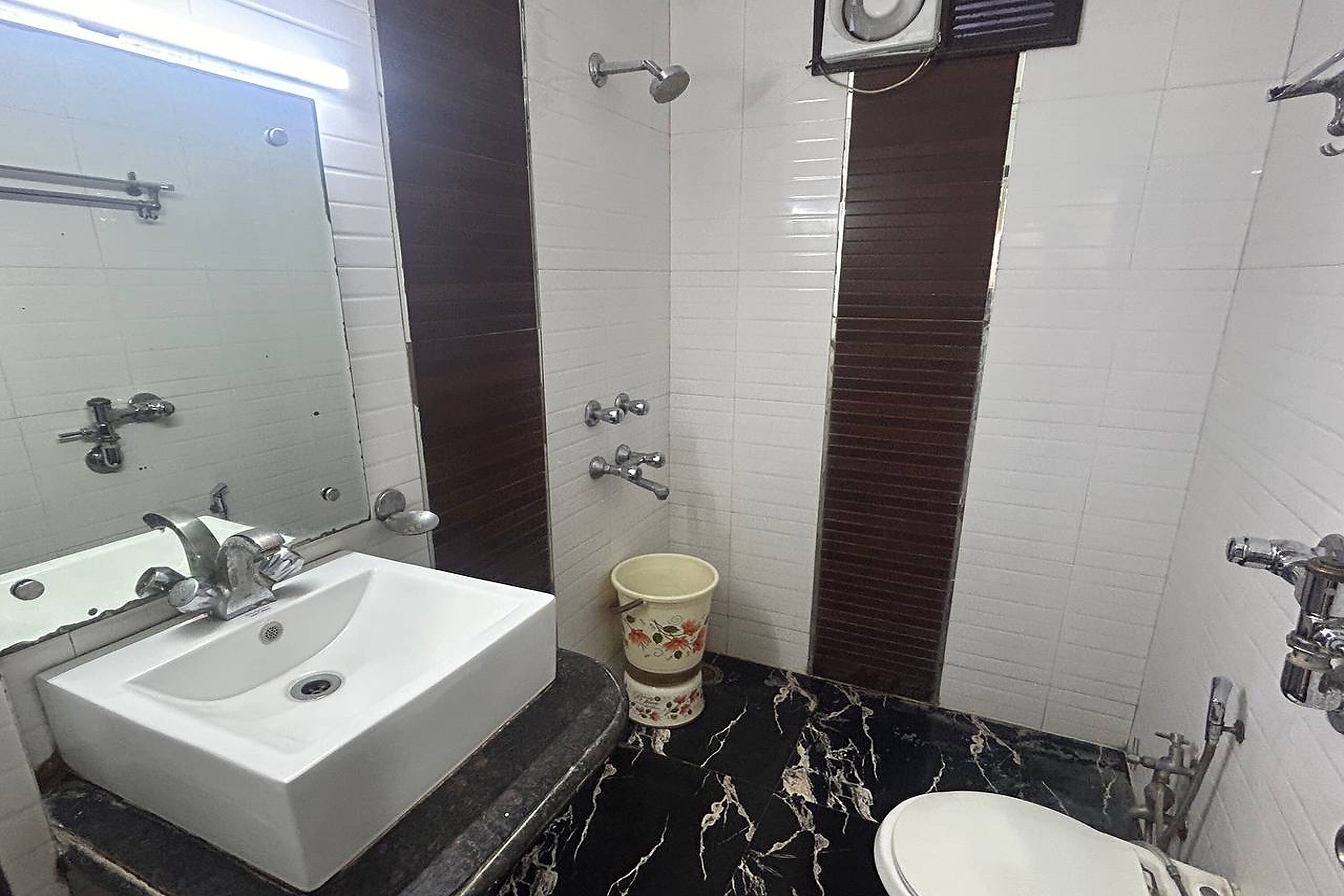 A bathroom with a white sink, a toilet, and a shower.