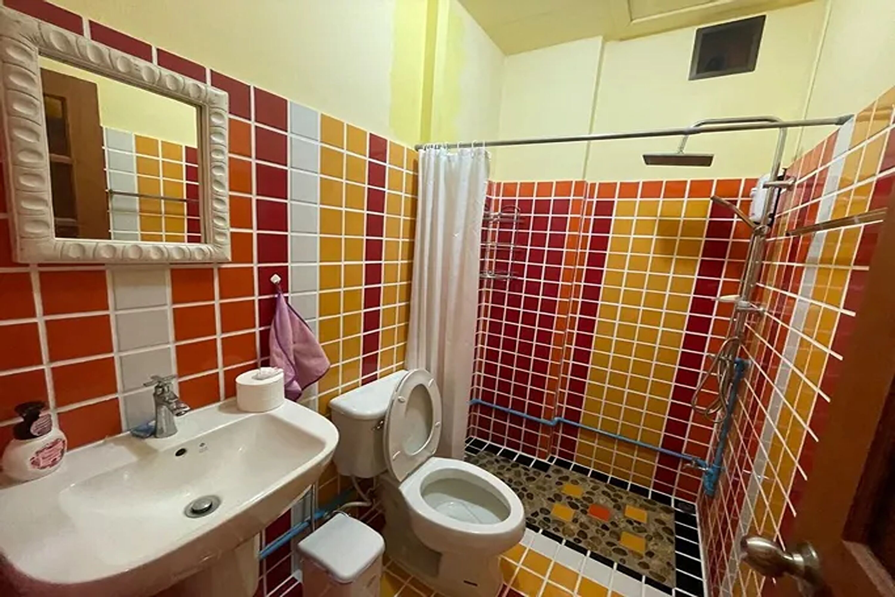 A bathroom with a toilet, sink, and shower area.