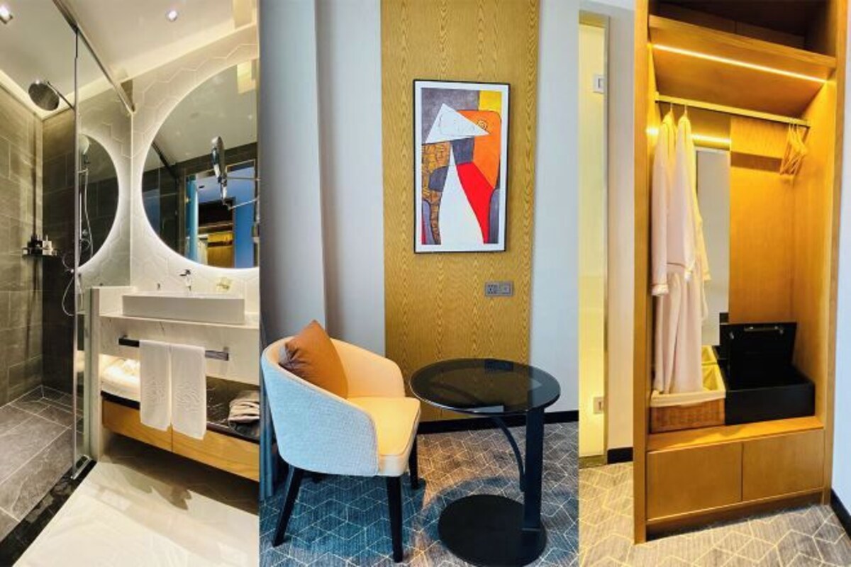 Une salle de bain moderne avec une douche à parois de verre, un meuble-lavabo, une chaise et une petite table.