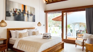 Un dormitorio amplio con una cama grande, cabecera de madera y un cuadro de paisaje urbano.