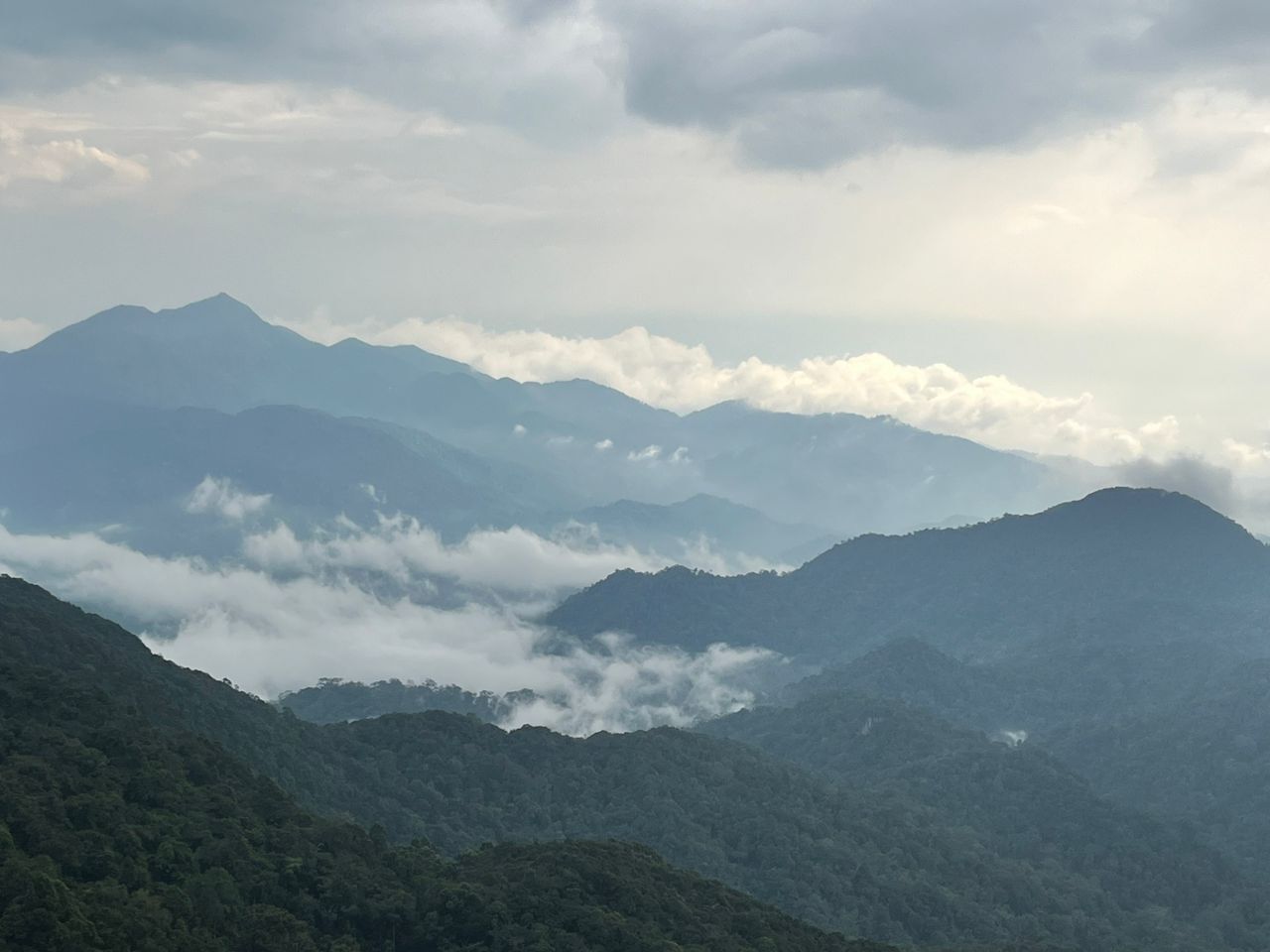 A mountainous landscape with a valley and cloud cover.