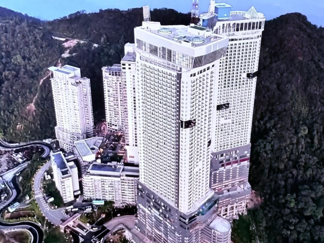 Un immeuble de grande hauteur, composé de plusieurs étages, entouré d’un paysage montagneux.