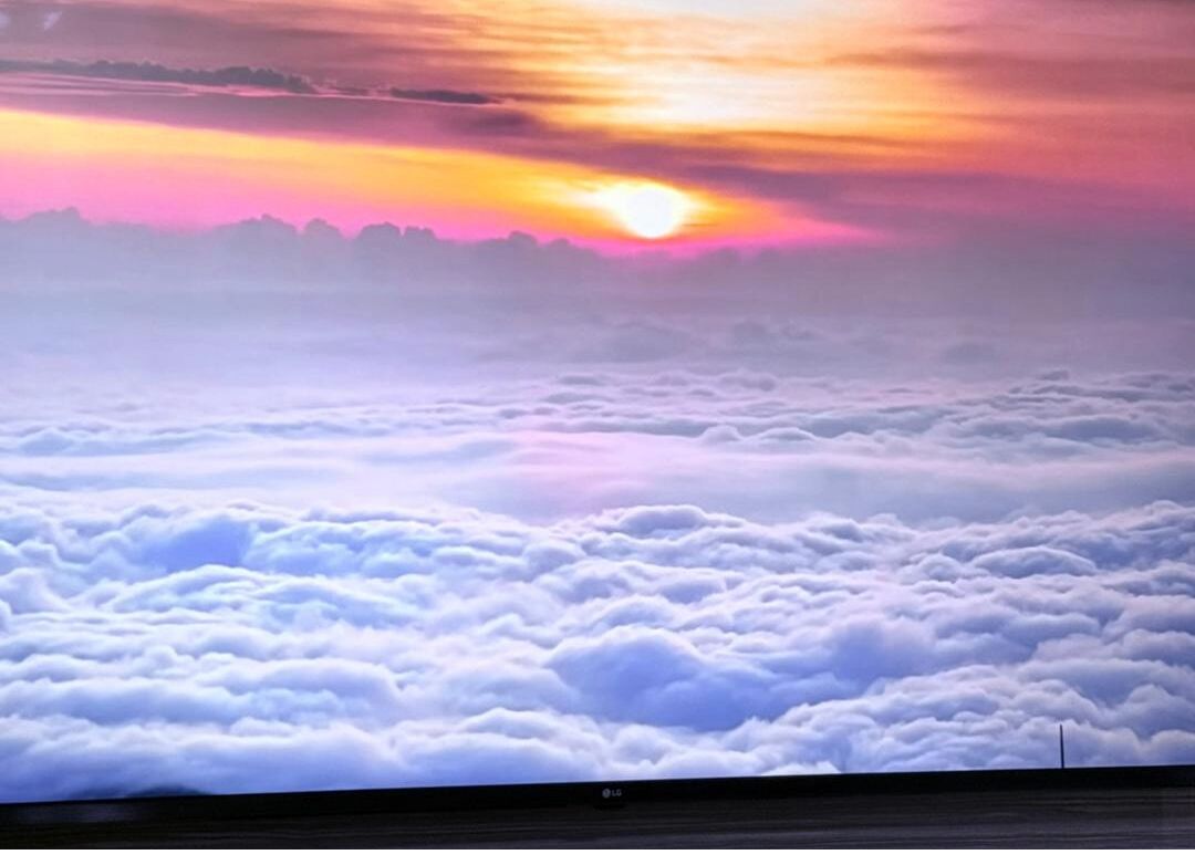 A sunset over a sea of clouds with a flat horizon.