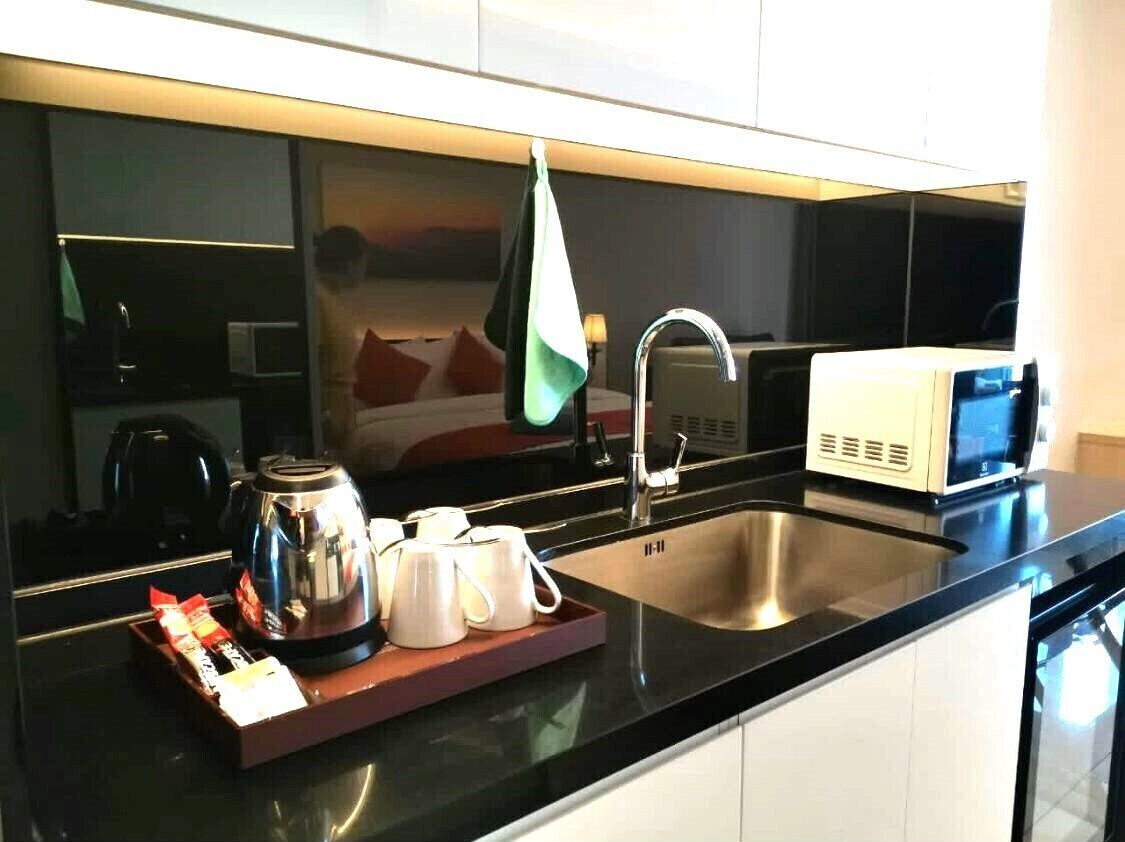 A modern kitchen with a stainless steel sink, a microwave, and a coffee maker on the counter.