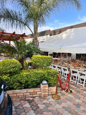 Enjoy meals under the shade of a pergola, surrounded by lush greenery and vibrant decor.
