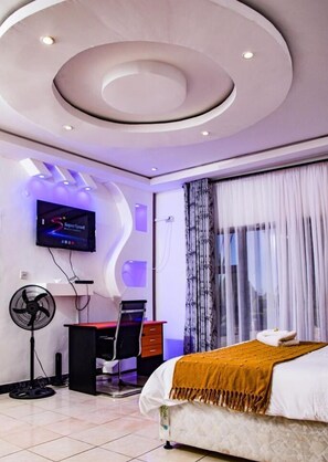 Relax in a stylish room with a curved ceiling, flat-screen TV, and large window.